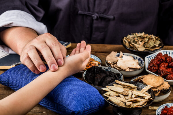 a tcm doctor taking a patient's pulse