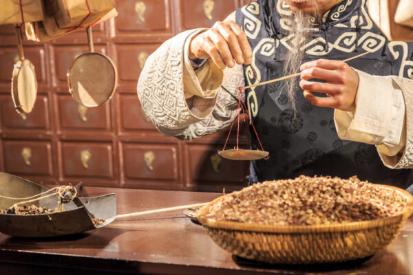 traditional chinese medicine doctor weighing herbs