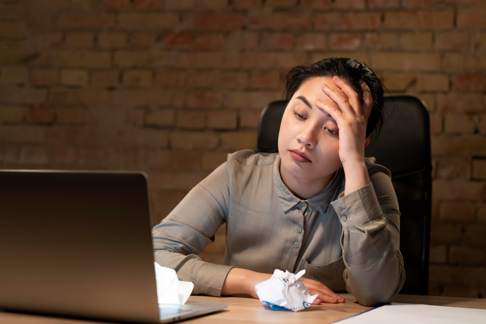 woman working late having stress and migraine