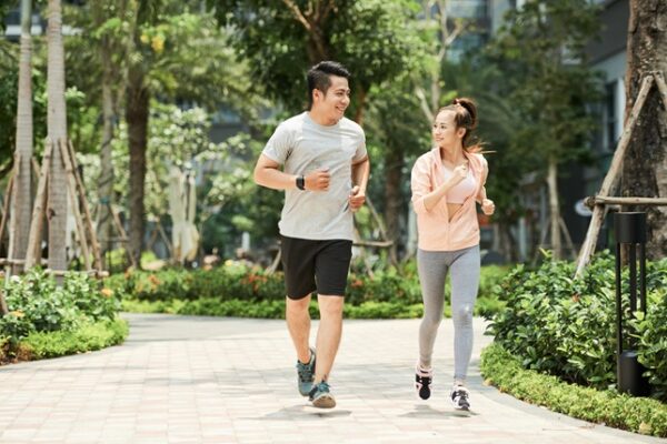 Vietnamese man and woman jogging together in the park